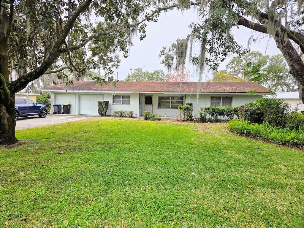 single story home with a garage and a front lawn