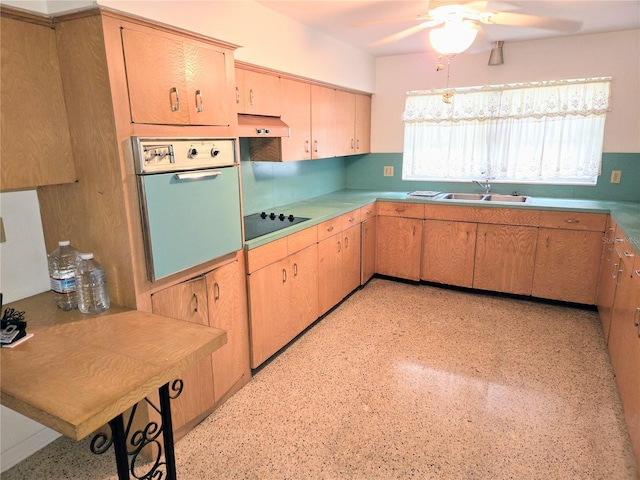 kitchen featuring sink, ceiling fan, range hood, black electric stovetop, and oven