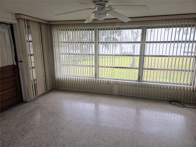 unfurnished sunroom with ceiling fan and a healthy amount of sunlight