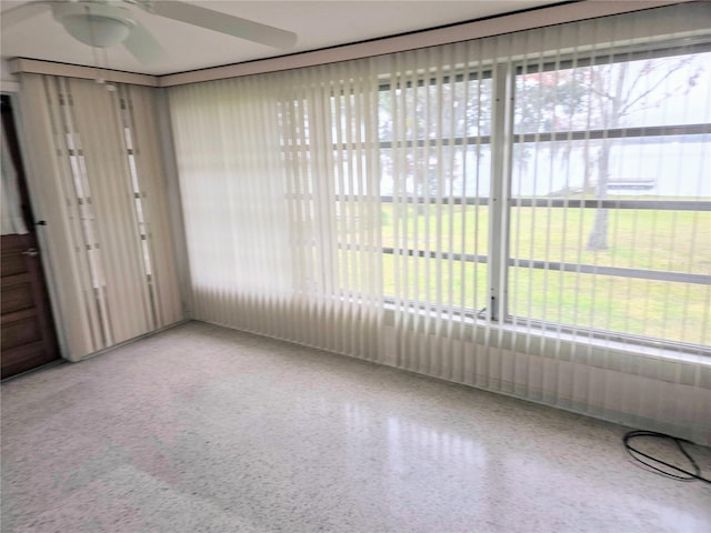 unfurnished sunroom with ceiling fan