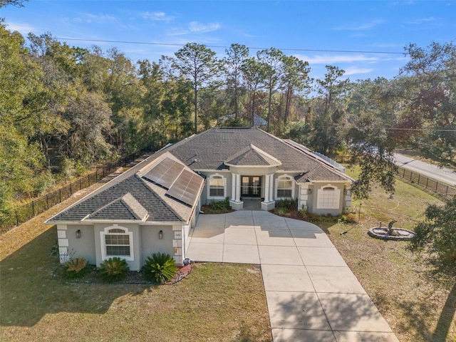 view of front of house with a front yard and solar panels