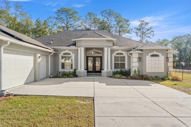 view of front of property with french doors, a garage, and a front yard