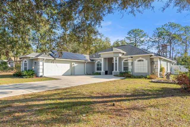 ranch-style house with a garage, a front yard, and solar panels