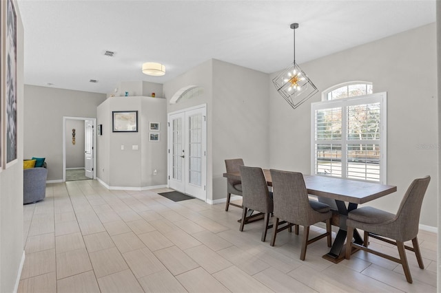 dining area featuring french doors and a chandelier