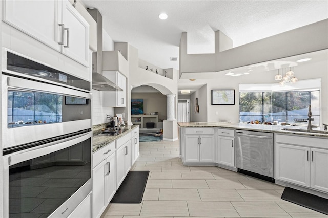 kitchen with appliances with stainless steel finishes, decorative light fixtures, tasteful backsplash, sink, and white cabinets