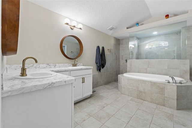 bathroom with tile patterned floors, vaulted ceiling, a textured ceiling, vanity, and independent shower and bath