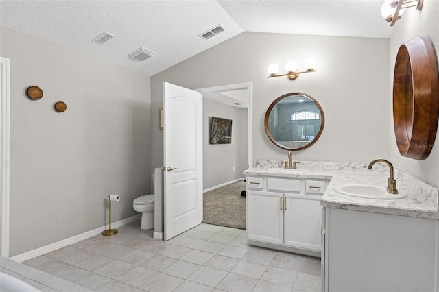 bathroom featuring lofted ceiling, vanity, toilet, tile patterned floors, and a textured ceiling