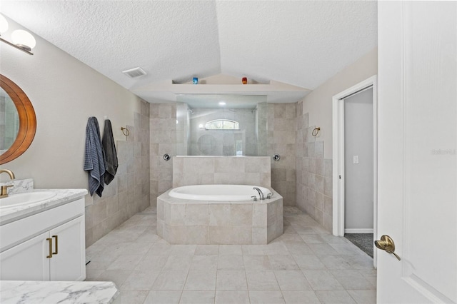 bathroom featuring lofted ceiling, vanity, independent shower and bath, and a textured ceiling