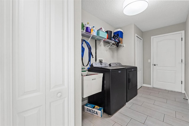 laundry room with washing machine and clothes dryer and a textured ceiling