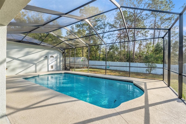 view of pool featuring a shed, a patio area, and glass enclosure