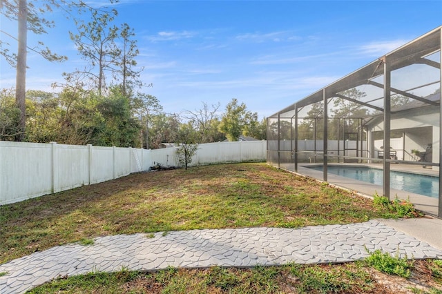 view of yard featuring a fenced in pool and glass enclosure