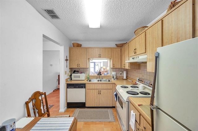 kitchen with sink, decorative backsplash, white appliances, light brown cabinets, and a textured ceiling