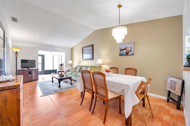 dining area featuring lofted ceiling, a notable chandelier, and light hardwood / wood-style floors