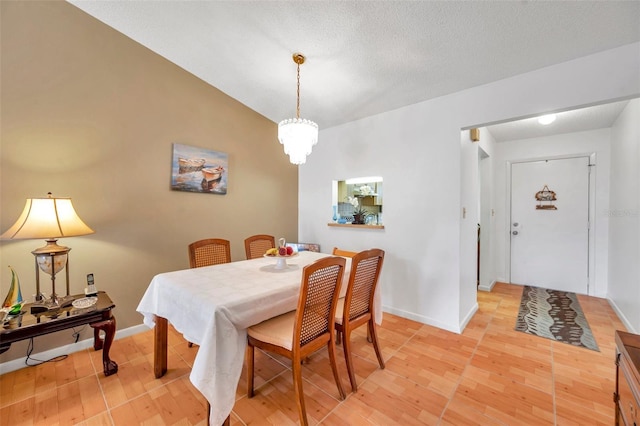 dining room featuring lofted ceiling, light hardwood / wood-style flooring, and a textured ceiling