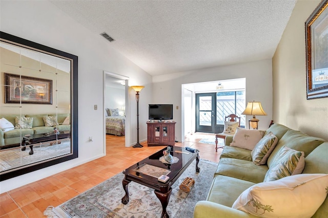 living room featuring vaulted ceiling, hardwood / wood-style floors, and a textured ceiling