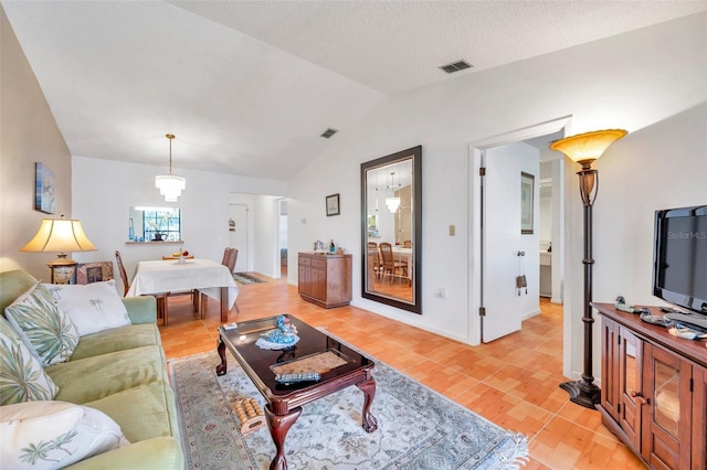 living room with vaulted ceiling, an inviting chandelier, a textured ceiling, and light wood-type flooring