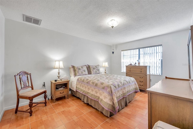 bedroom featuring light hardwood / wood-style floors and a textured ceiling