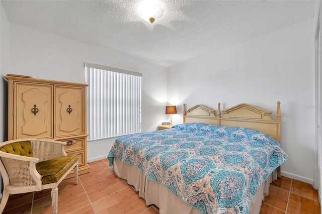 bedroom featuring light hardwood / wood-style flooring and a textured ceiling