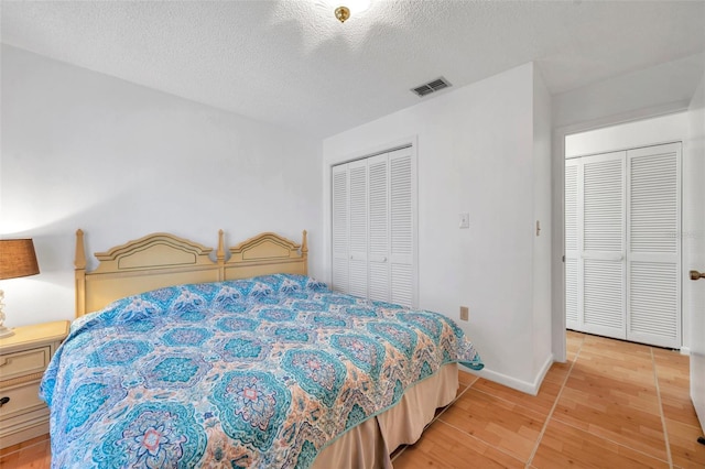 bedroom with a closet, a textured ceiling, and light wood-type flooring