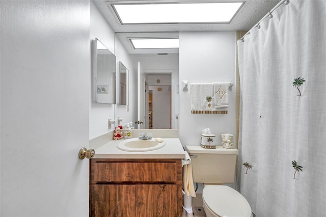 bathroom featuring vanity, a skylight, and toilet