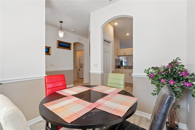 dining room featuring washer / dryer and light hardwood / wood-style flooring