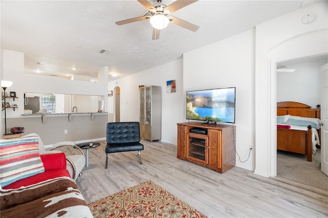 living room featuring ceiling fan and light wood-type flooring