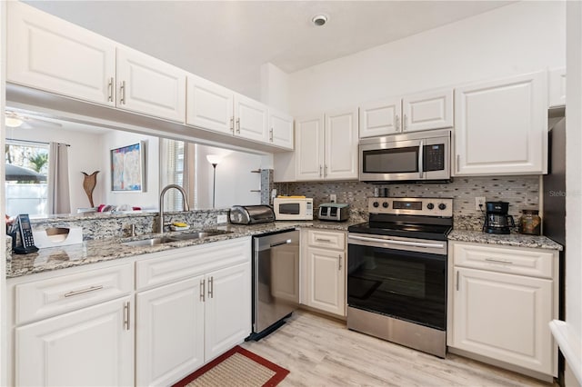 kitchen featuring white cabinetry, appliances with stainless steel finishes, sink, and backsplash