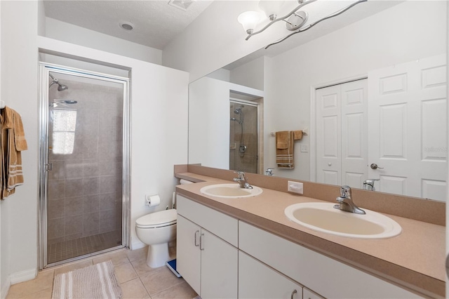 bathroom featuring vanity, toilet, an enclosed shower, and tile patterned flooring