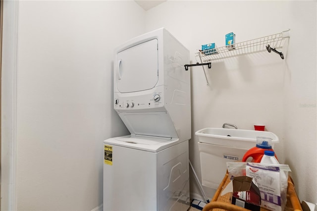 clothes washing area featuring stacked washer / drying machine