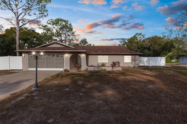 ranch-style home with a garage and a lawn