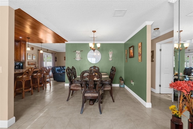 tiled dining space with an inviting chandelier, crown molding, and a textured ceiling