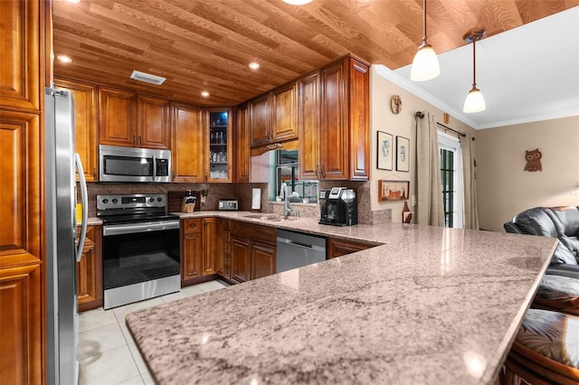 kitchen with light tile patterned flooring, appliances with stainless steel finishes, decorative light fixtures, a kitchen bar, and kitchen peninsula