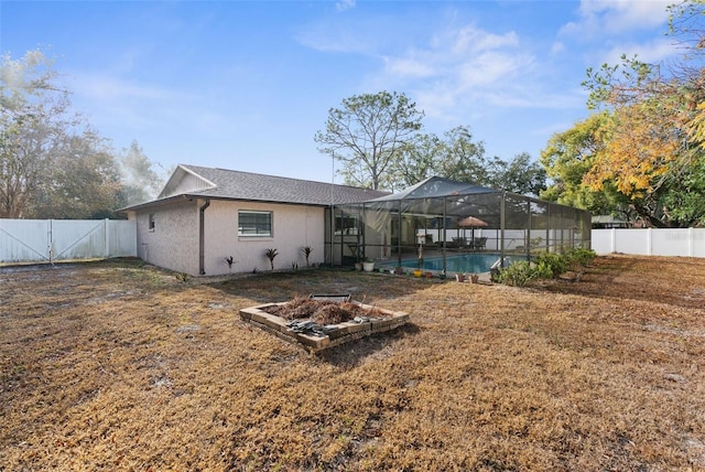 rear view of property featuring a fenced in pool, a yard, and glass enclosure