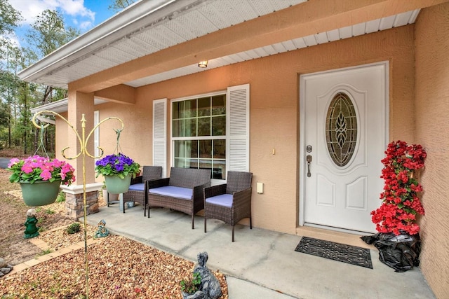 entrance to property with a patio area and stucco siding