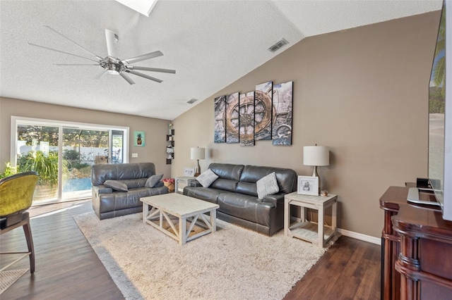 living room featuring ceiling fan, dark hardwood / wood-style floors, vaulted ceiling, and a textured ceiling