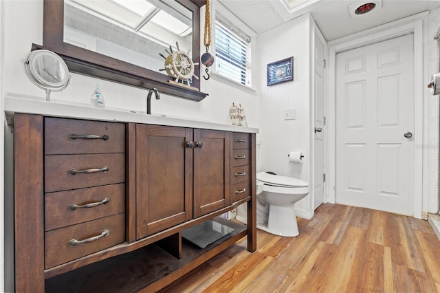 bathroom featuring vanity, toilet, and hardwood / wood-style floors