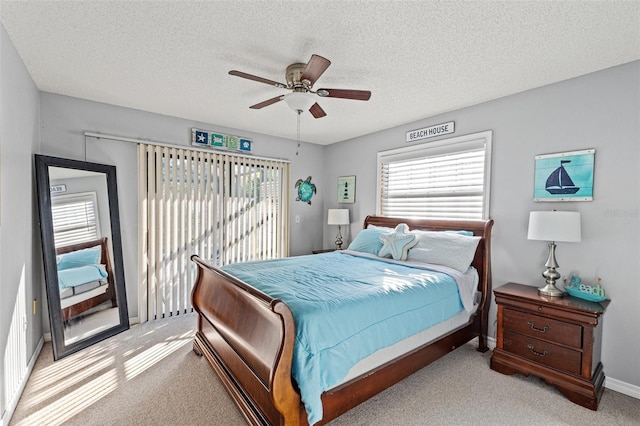 bedroom featuring multiple windows, access to outside, light colored carpet, and a textured ceiling