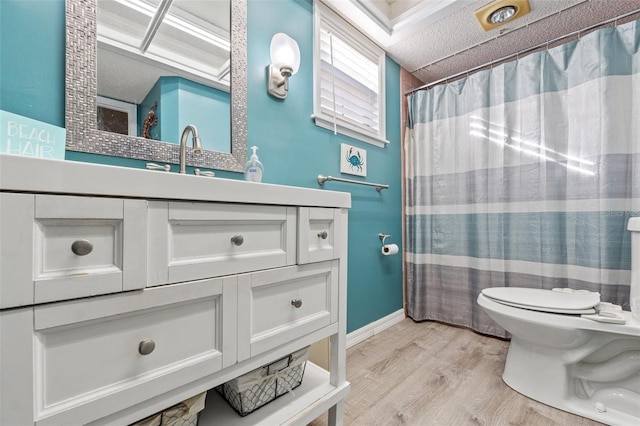 bathroom featuring hardwood / wood-style flooring, vanity, toilet, and curtained shower