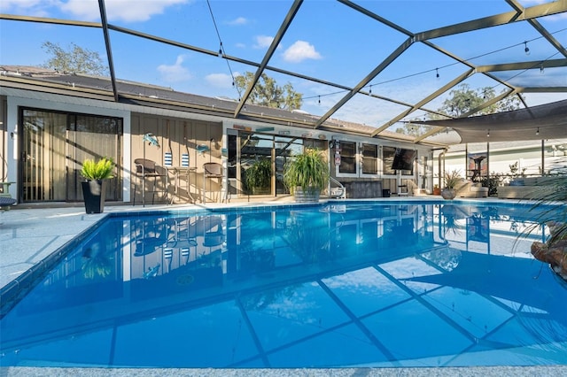 view of pool with a patio, an outdoor bar, and glass enclosure