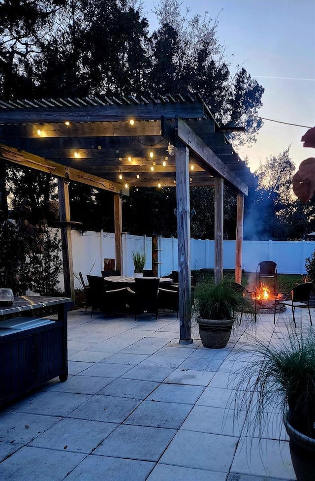 patio terrace at dusk featuring a pergola