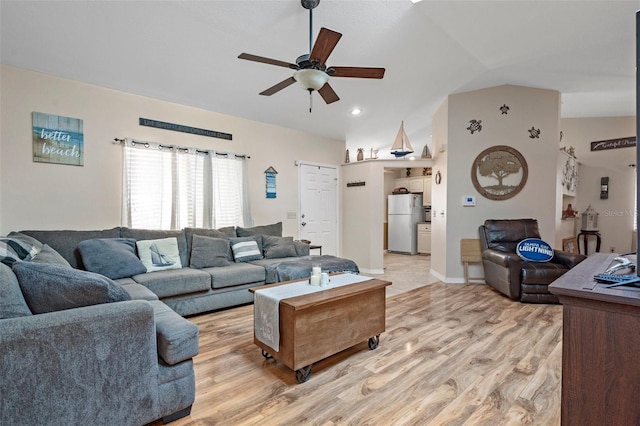 living room with ceiling fan, lofted ceiling, and light hardwood / wood-style floors