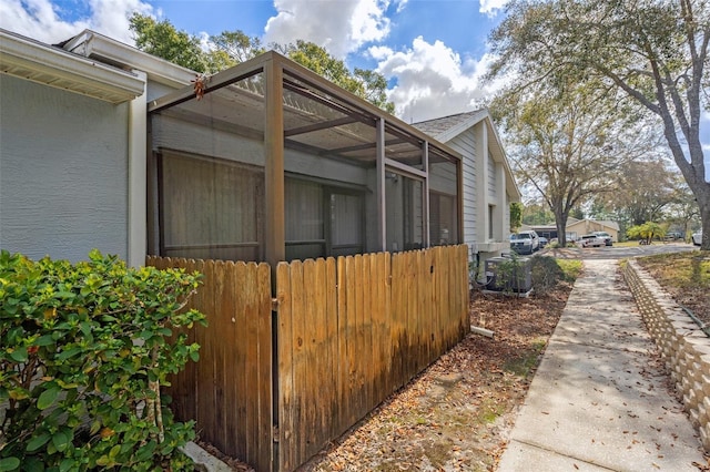 view of property exterior with glass enclosure