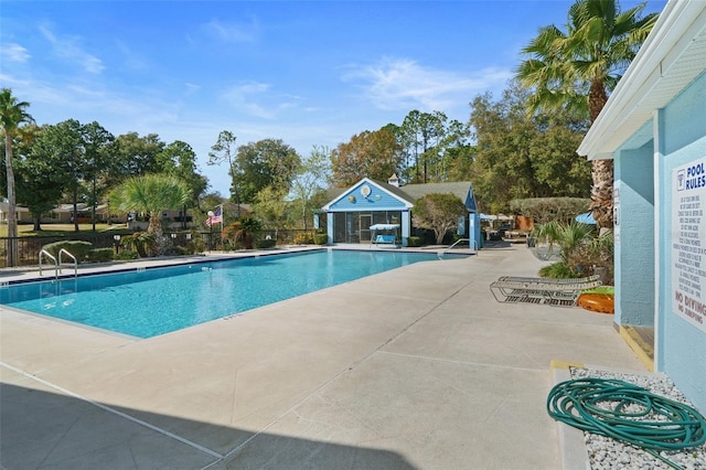 view of swimming pool featuring an outdoor structure and a patio area