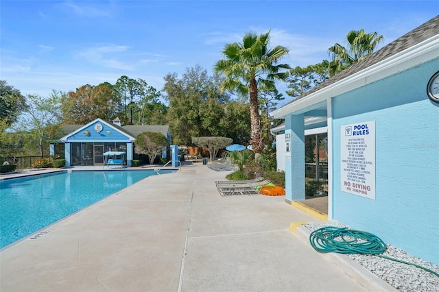 view of swimming pool with an outdoor structure and a patio area