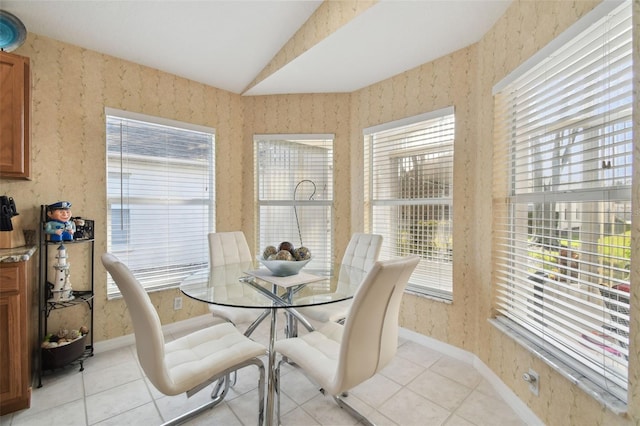 dining space with lofted ceiling and light tile patterned floors