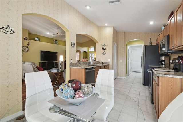 kitchen featuring stainless steel appliances, sink, light tile patterned floors, and ceiling fan