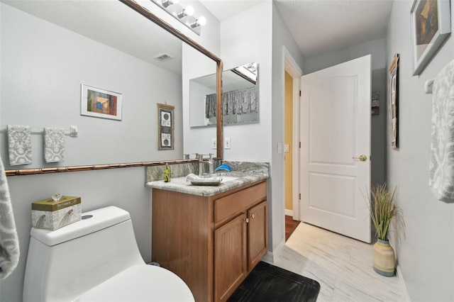 bathroom featuring vanity and toilet