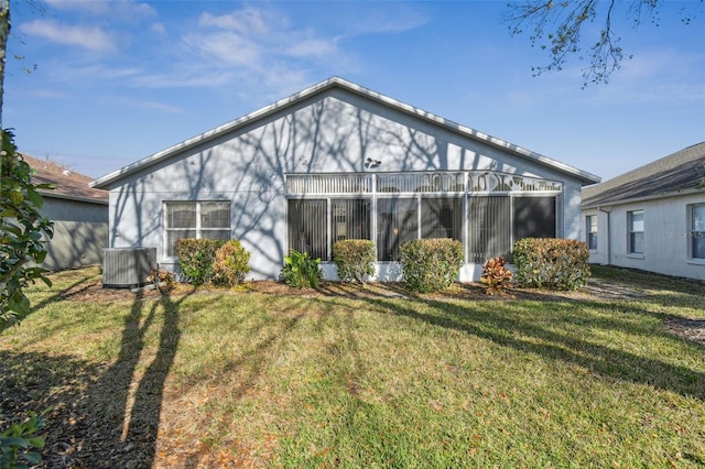 back of property with a yard and central AC unit