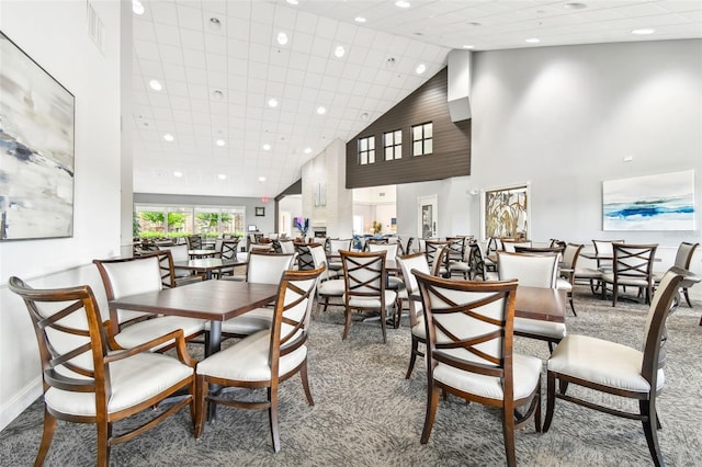 dining space featuring carpet floors and high vaulted ceiling