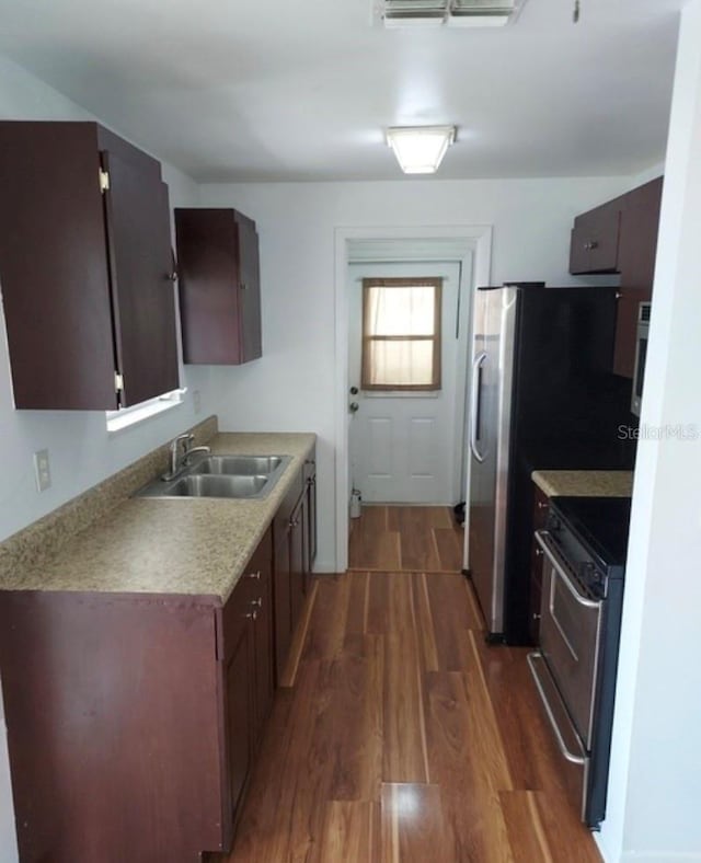 kitchen featuring electric stove, sink, and dark hardwood / wood-style flooring